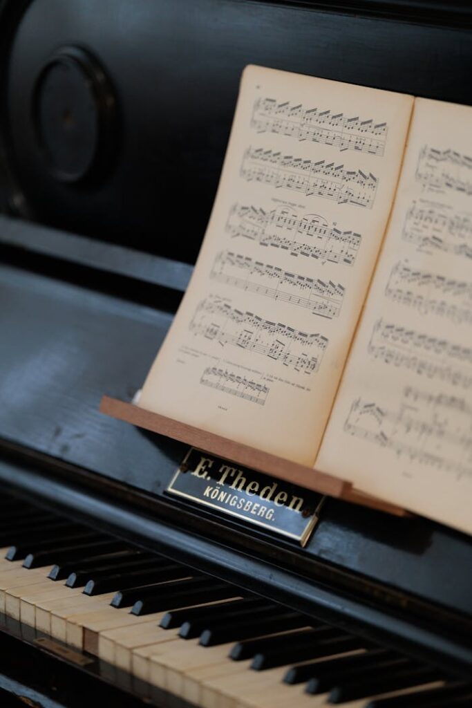 Home Close-up of a classic upright piano with open sheet music and brand label "E. Theden, Königsberg."